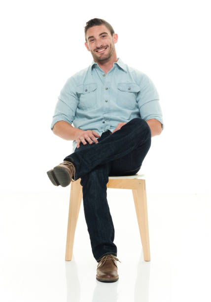charming man seated and smiling - sitting on a chair imagens e fotografias de stock