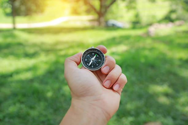 istock Hand holding a compass against nature background. 922290946