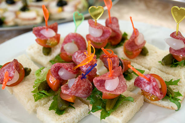 Close-up of tortilla roll-up appetizers with cream cheese and meat on a party platter