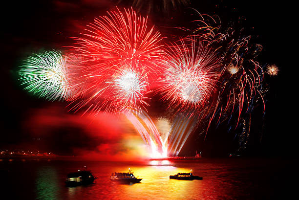 Fireworks launched in a still harbour.
