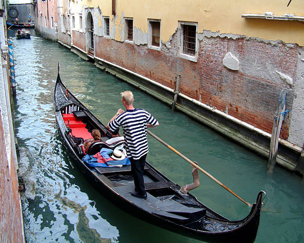 istock Gondolier in narrow Venice canal 92230163