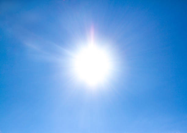 istock Sun shining on the blue sky with clouds, looking up view 922304564
