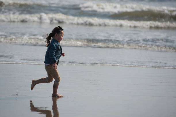 istock Little girl playing in the winter beach 922318318