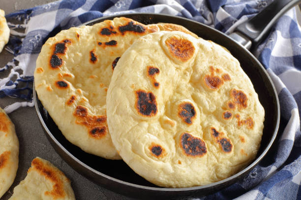 freshly fried pita bread in skillet freshly pan fried pita bread in skillet with kitchen towel on concrete table, view from above, close-up mexican culture food mexican cuisine fajita stock pictures, royalty-free photos & images