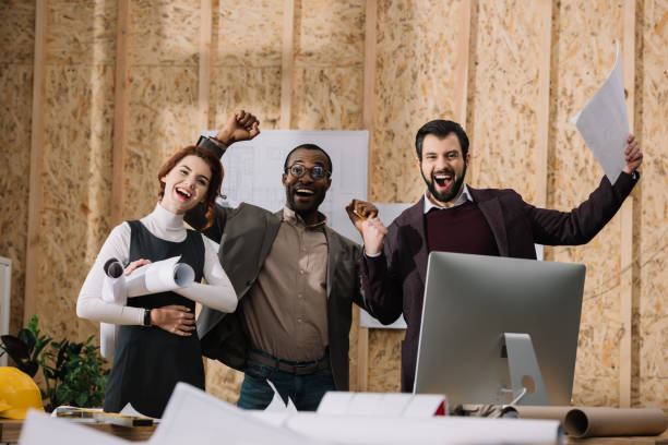 istock multiethnic celebrative team of architects with papers at modern office 922318784
