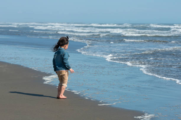 istock Little girl playing in the winter beach 922321084