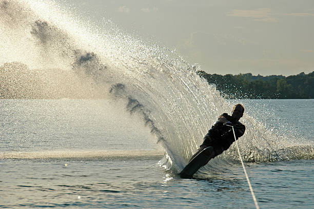 Young sports man falling into the river during waterskiing on a sunny summer day.