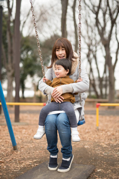 istock Mother holding child in arms on swing 922330400
