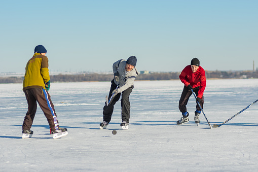 Dnepr, Ukraine - January 22, 2017: People of different ages playing hockey on a frozen river Dnepr in Ukraine