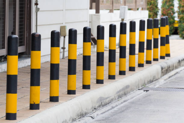 istock yellow and black steel bollards on footpath 922335670