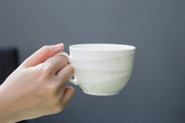 istock asian women right hand hold white coffee cup on grey background 922335956
