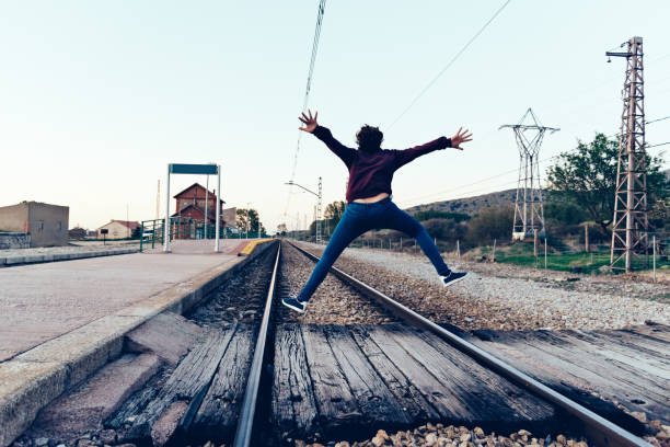 istock Young woman is jumping on the railroad tracks at old railroad st 922338564