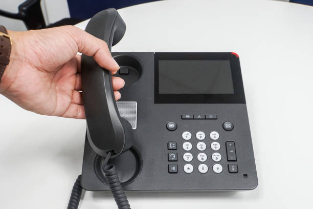 istock close up businessman off hook IP phone calling out to customers 922340824