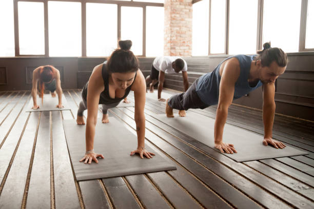 istock Group of young sporty people standing in Plank pose 922344966