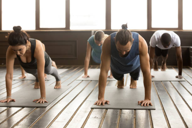 istock Group of young people standing in Plank pose 922344976