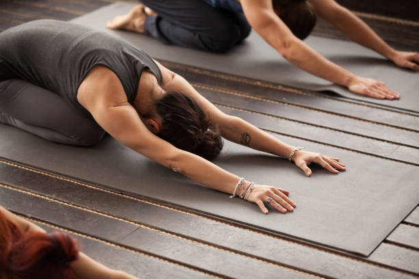 istock Group of young people in Balasana pose 922344984