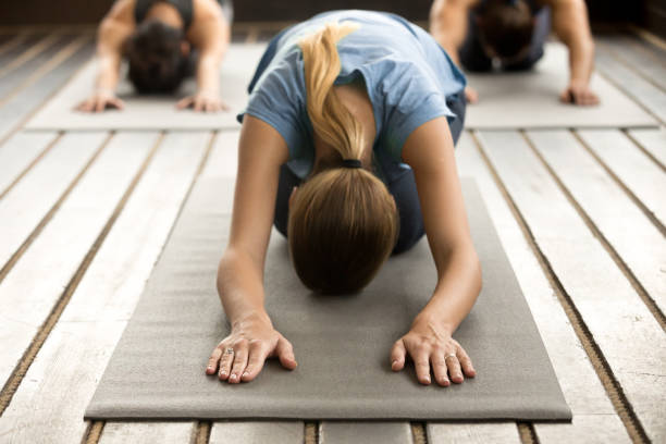 istock Group of young people in Balasana pose 922344996