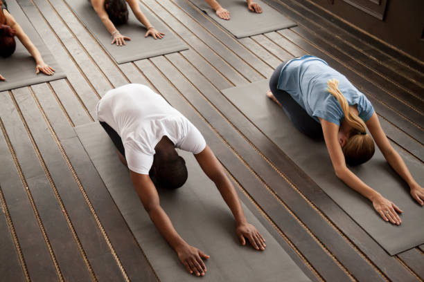 istock Group of young people in Balasana pose, top view 922345002