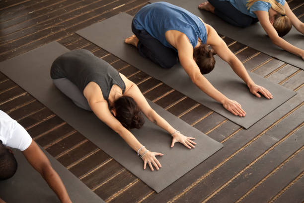 istock Group of yogi people in Child pose 922345006