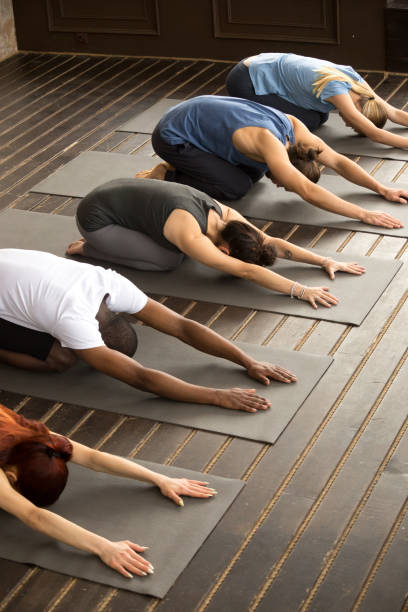 istock Group of yogi people in Balasana pose 922345022