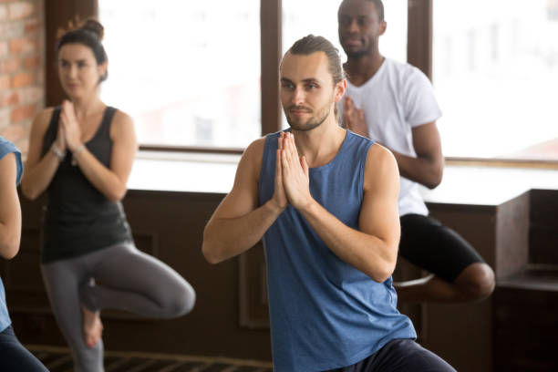 istock Group of sporty people in Tree pose 922345040
