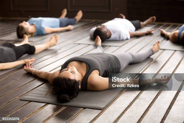 Gruppo Di Sportivi A Savasana Posa - Fotografie stock e altre immagini di Yoga - Yoga, Esercizio di respirazione, Rilassamento