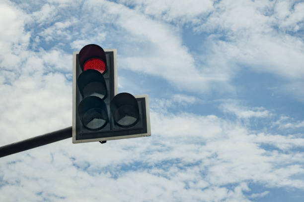 istock Traffic light with red color on blue cloudy sky background 922347890