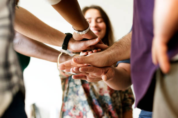 groupe de personnes divers rejoint mains ensemble travail d’équipe - holding hands human hand holding multi ethnic group photos et images de collection