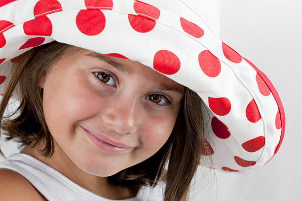 Smiling young girl in polka-dot hat stock photo