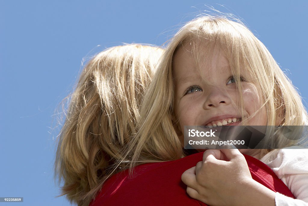 A rapariga abraçar a mãe contra Céu - Royalty-free Cabelo Humano Foto de stock