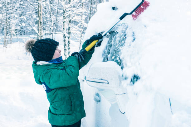 istock boy is cleaning the car from the snow 922359782