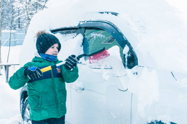 istock boy is cleaning the car from the snow 922359794