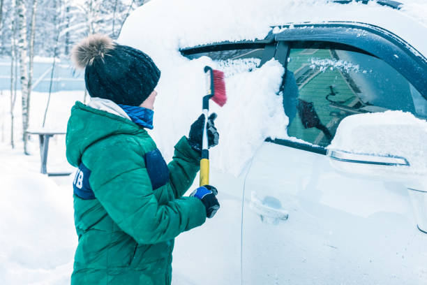 istock boy is cleaning the car from the snow 922359796