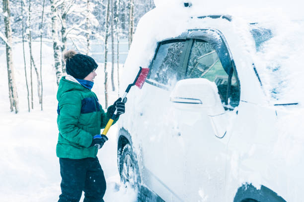 istock boy is cleaning the car from the snow 922359810