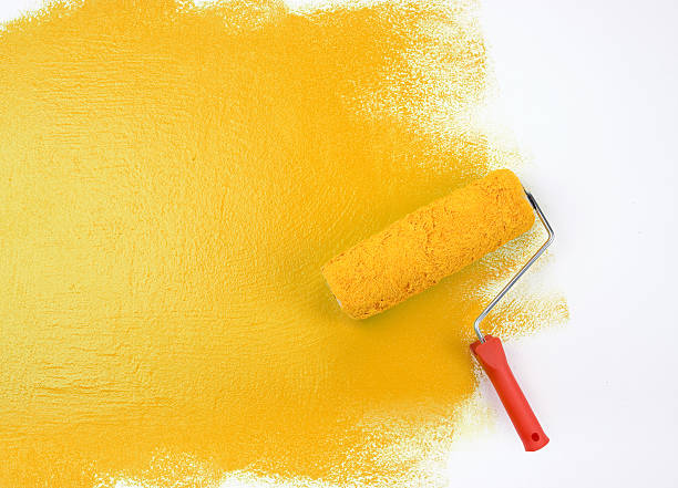 jaune rouleau à peinture - painting wall paint paint roller photos et images de collection