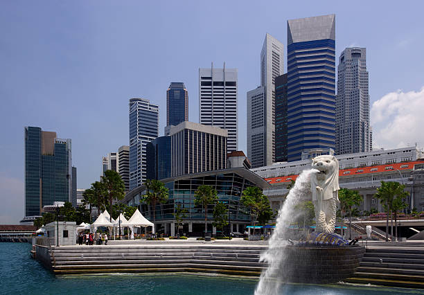 Singapore, Republic of Singapore - May 4, 2016: Singapore central quay at sunrise with Merlion lion fountain on foreground