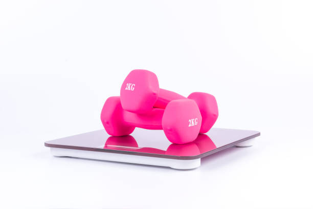 istock Pink dumbbells on a weighting scale 922362748