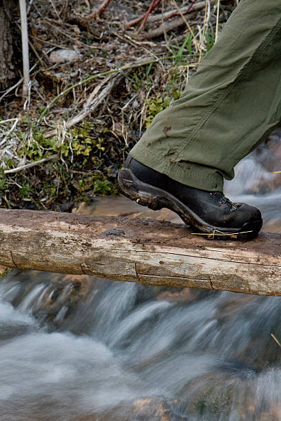 istock Hiker stepping on log foot bridge 92236527