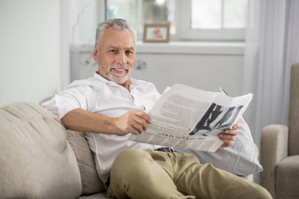 szczęśliwy emeryt odpoczywa w domu - healthcare and medicine healthy lifestyle finance newspaper zdjęcia i obrazy z banku zdjęć
