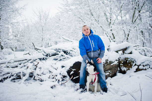 istock Man with husky dog at winter snowy park. 922371998