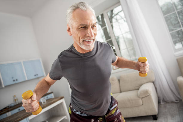 istock Handsome pensioner lifting sport equipment 922372536