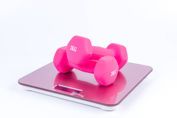 istock Pink dumbbells on a weighting scale 922372846