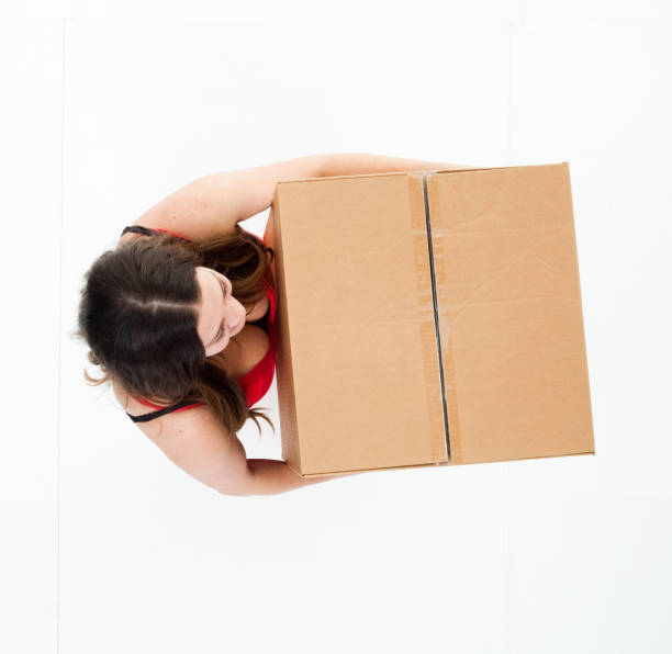 istock High angle view of young woman holding cardboard box 922373356