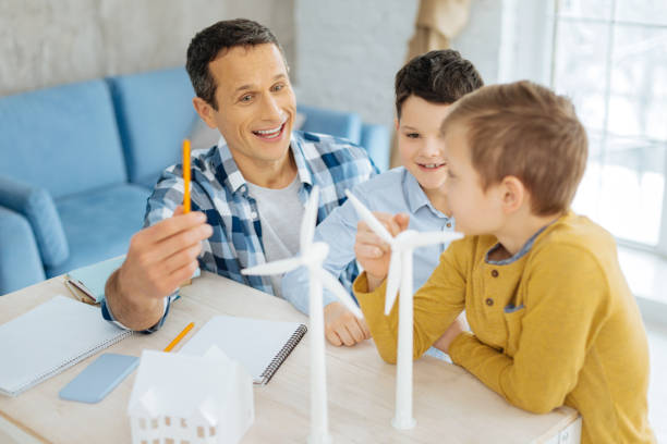istock Happy father chatting cheerfully with sons about his work 922375778