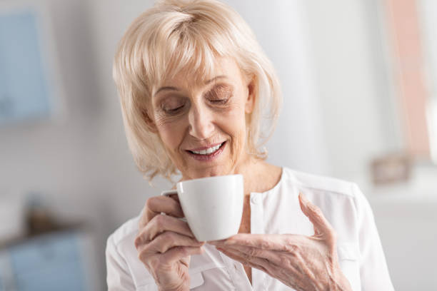 istock Adorable mature woman sniffing coffee 922376548