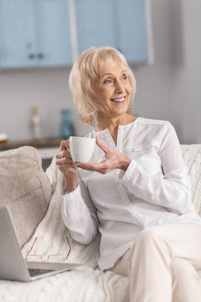 istock Dreamful mature woman distracting from laptop 922376636