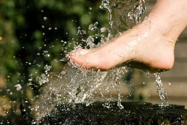 Splash of cold water showered on feet in an alternative therapy session; drops frozen