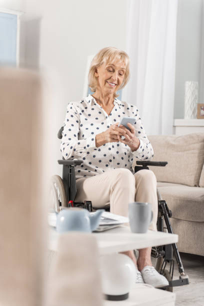 istock Disabled mature woman using phone 922380056