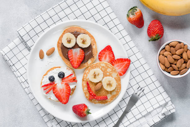 istock Funny pancakes with animal faces for kids on white plate 922383618
