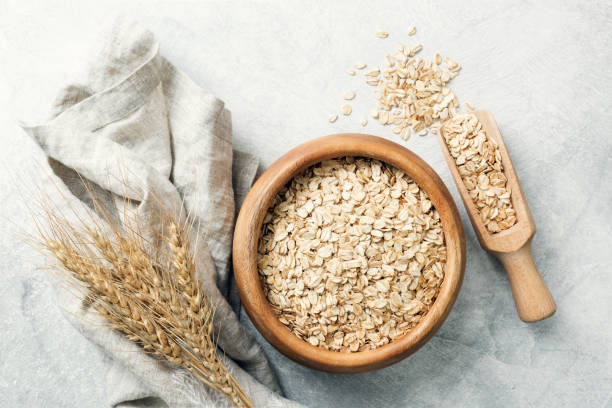 Rolled oats in wooden bowl and ears of wheat stock photo